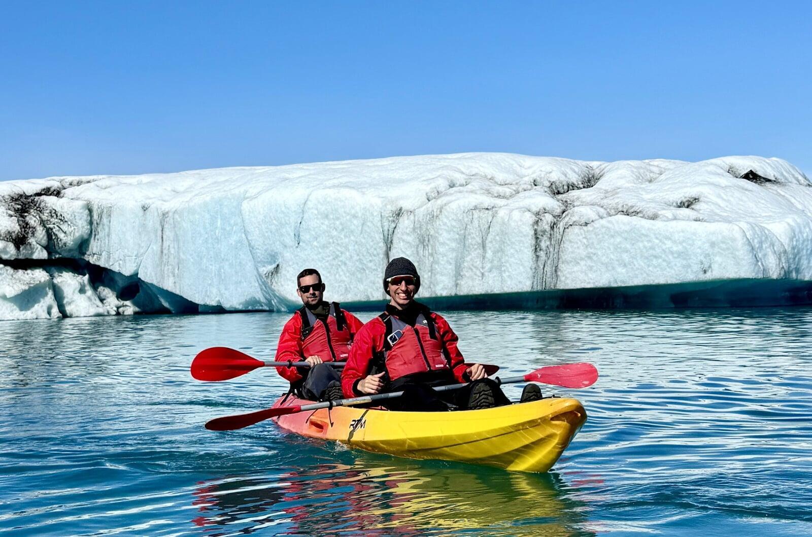 image 2 hommes en rouge sur un kayak souriant devant glacier